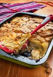 Potatoes au gratin with sautéed onions, with a selected meat